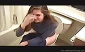 Dark haired beauty can't stand the smell of poop