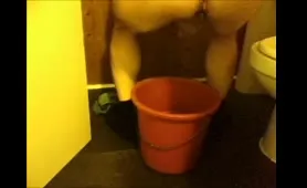 Nude Woman Squats Over a Bucket and Pisses